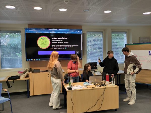 Präsentation und Vortrag zum Thema Nachhaltigkeit auf einem großen Bildschirm in einem Konferenzsaal.