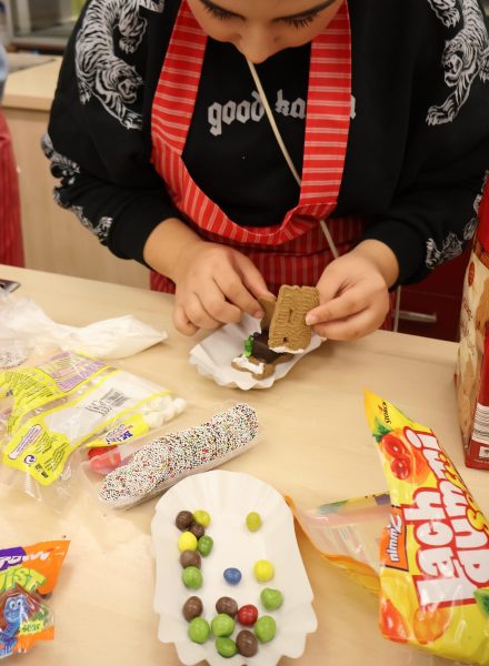 Eines Schülerin baut ein kleines Lebkuchehaus aus Spekulatiuskeksen zusammen.