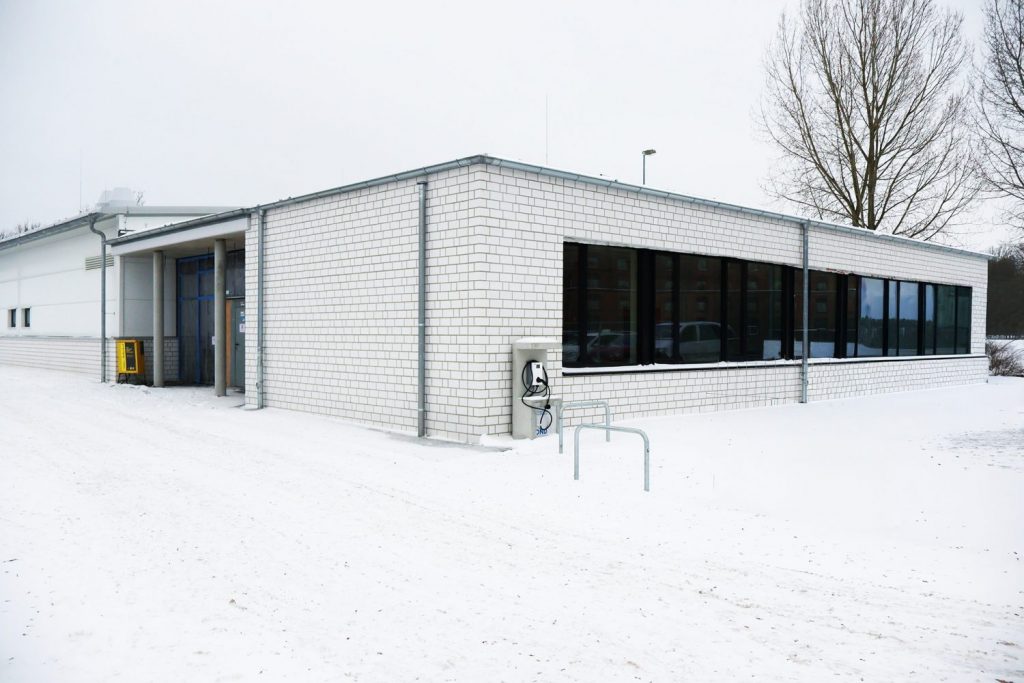 Die neue Bauhalle des BBZ-NOK. EIn einstöckiges Gebäude mit einer langen Fensterfront. Es liegt Schnee.