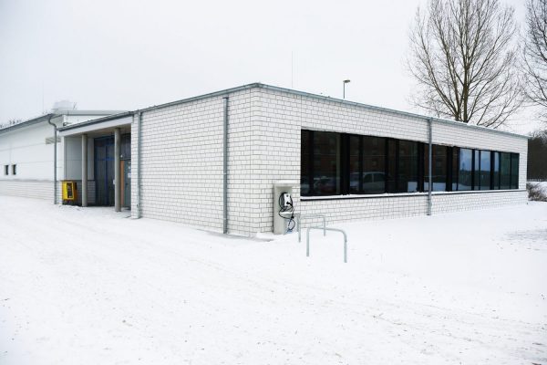 Die neue Bauhalle des BBZ-NOK. EIn einstöckiges Gebäude mit einer langen Fensterfront. Es liegt Schnee.